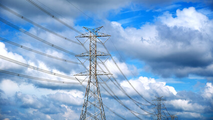 Transmission line pylon lattice tower, blue sky with clouds background