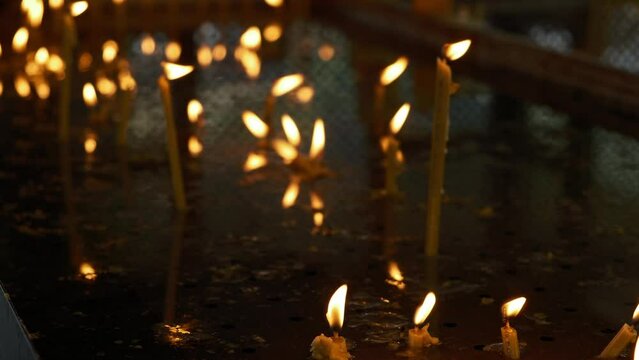 Burning candles that stand in a row. Lighted memorial candles. Candles burn in an Orthodox church. Theme religious faith and God, culture and traditions of Orthodoxy.