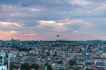 Evening panorama of Istanbul. The Turkish flag fluttering in the sky.