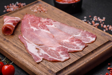 Slices of delicious smoked jamon or prosciutto with salt, spices and herbs