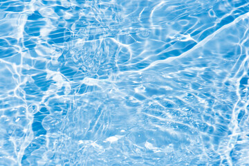 Defocus blurred transparent blue colored clear calm water surface texture with splashes reflection. Trendy abstract nature background. Water waves in sunlight with copy space. Blue watercolor shine.