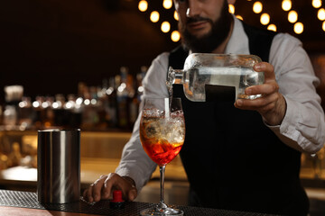 Bartender making fresh alcoholic cocktail at bar counter, closeup - obrazy, fototapety, plakaty