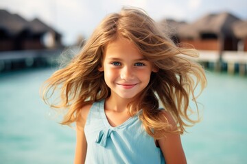 Cute little blonde girl, portrait of innocence. Her beautiful, playful expression radiates happiness on a seaside holiday. - Powered by Adobe