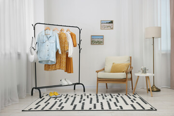 Stylish showroom interior with clothing rack and armchair