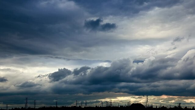 Landscape of fast moving dark clouds and high voltage power tower