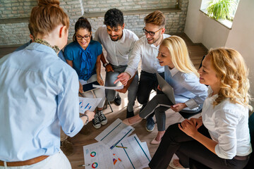 Fototapeta premium Diverse businesspeople discuss financial report in charts diagrams and graphs in meeting