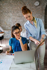 Obraz premium Business women entrepreneurs working in coworking space smiling, brainstorming as a team in office