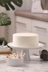 Delicious cake and sweets for decoration on white marble table in kitchen