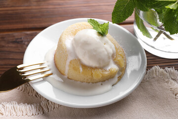 Delicious vanilla fondant served with ice cream on wooden table, closeup