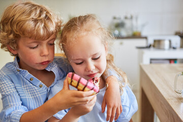 Brother and sister sharing donuts at home