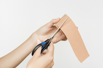 Female hands cut off kinesio tape on a white background