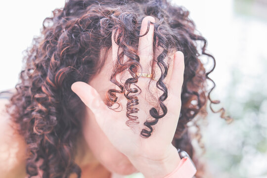 Close-Up of a woman's hand holding a ringlet of hair