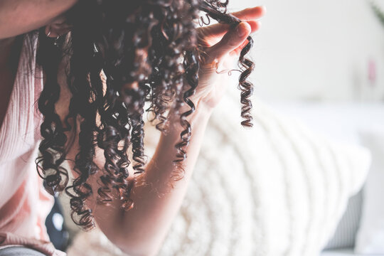 Close-Up of a woman's hand holding a ringlet of hair