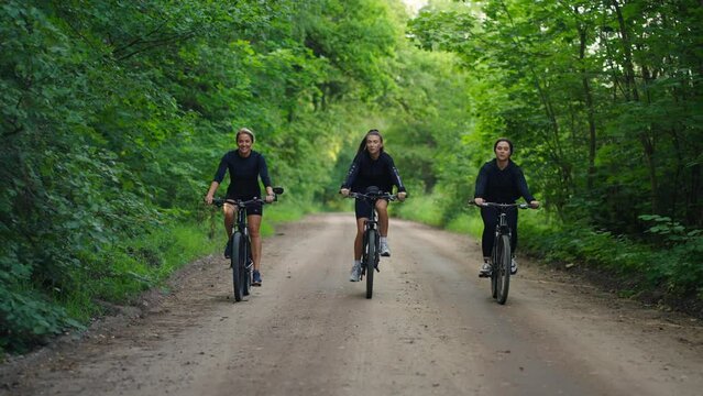 Riding Bikes In Forest In Summertime, Three Slender Girls Friends Enjoying Good Weather In Weekend