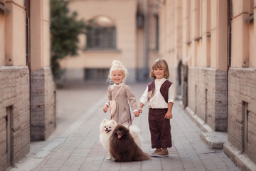 Girl and boy with two dogs on the city street talking and laughing 