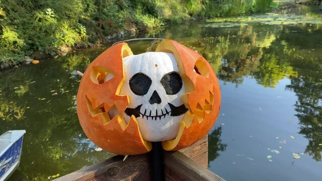 As part of Halloween preparations, a spooky face made from a carved and painted pumpkin decorates the garden. Carving pumpkins is a customary step in getting ready for Halloween in the park