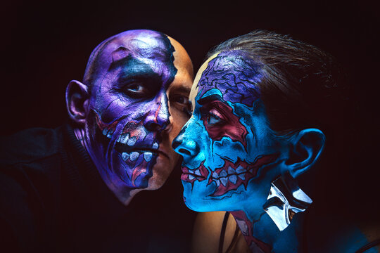 Photo of a demonic couple of zombies on the dark background.