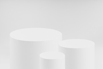 Abstract three white round cylinder podiums for cosmetic products as mockup on white background for presentation products, gifts, goods, advertising, design, sale, text, display, showing.