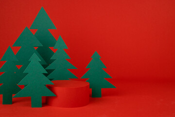 Obraz premium Christmas background - one cylinder podium, scene with 3d rendering for presentation gifts, cosmetics, goods in red color, green spruce forest, closeup. New year celebration template for advertising.