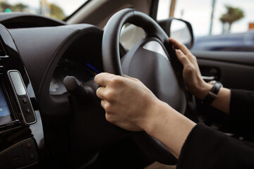 Driving a car photo background. Steering wheel and hands of a driver, city car interior