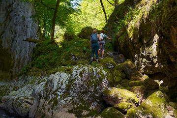 Naklejka na ściany i meble Woman hikers exploring a gorge