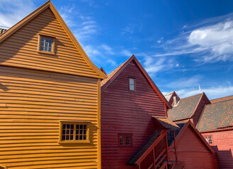 colorful wooden houses against the blue sky, yellow, red and orange old building in Bergen