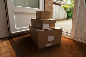 Delivery of parcels on doormat of domestic house. All labels are illegible or dummies.