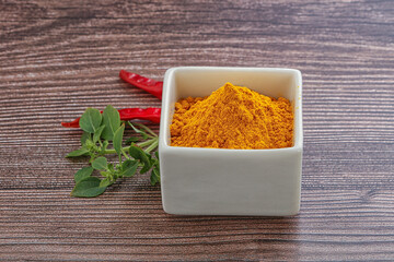 Yellow vibrant curcuma powder in the bowl