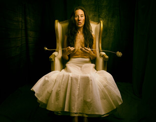 Fototapeta premium woman in white skirt sitting in an antique armchair