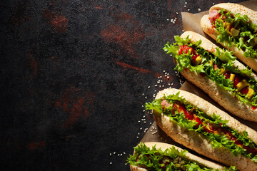 Hot dogs on dark gray background, space for text