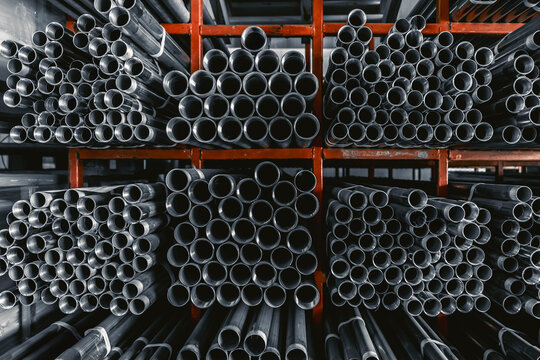Metal pipes connector tubes. Construction cylindrical steel pipe stacked valious size in construction equipment store shelf.