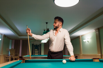 Billiard player at billard table or snooker american billiards pool sport game