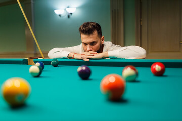 Fototapeta premium Billiard player calculate trajectory pathway at billard table or snooker american billiards pool sport game