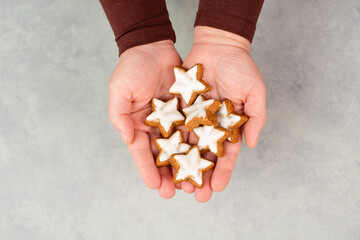 Obraz premium Cinnamon stars, Zimtsterne traditional german christmas cookies in the hands, gingerbread with anise spice for holidays 