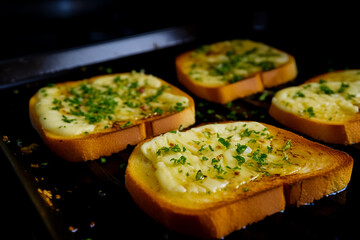 Garlic paste on toasted bread slices. Closeup.