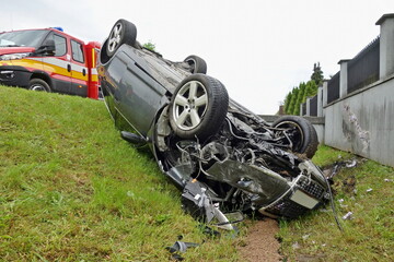 Car accident. An overturned car lying upside down on the street after an accident. The car crashed...
