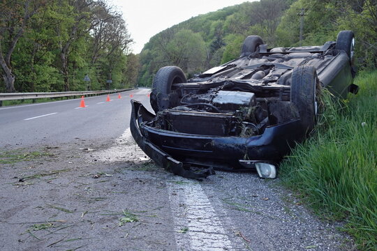 Car accident. An overturned car lying upside down on the street after an accident. The car crashed on the road and overturned. Real event. 