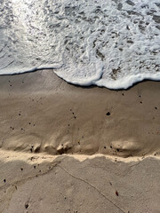 Aufsicht - Wellen brechen am Strand