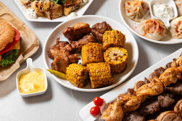 set of different grilled meat and corn on a with plates, grilled food for banner and menu