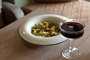 italian pasta on a wooden table with red wine light from the window