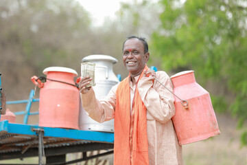 happy Indian farmer selling milk in farm