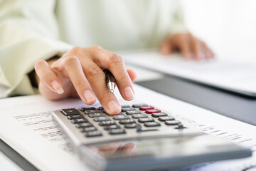 Close-up shot of woman pressing a calculator to review and summarize the cost of mortgage home loans for refinancing plans, lifestyle concept.