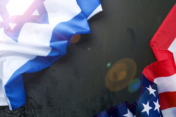 USA Israel flags. Two American and Israeli flags lie on black old concrete texture background...