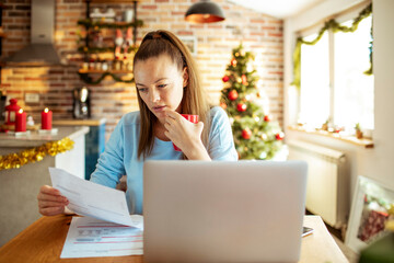 Young woman doing financials during the Christmas holidays at home