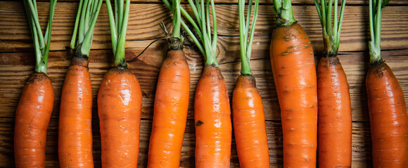 Fresh carrots on wooden table.