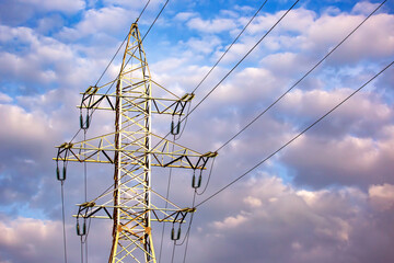 Energy industry. High voltage tower with power wires against the background of clouds.