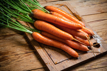 Fresh carrots on wooden table.