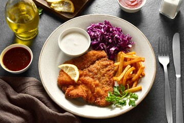 Schnitzel with potato fries, cabbage salad and sauce