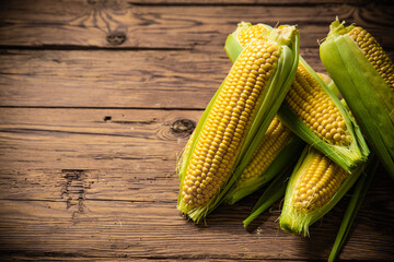 Fresh corn on wooden table.