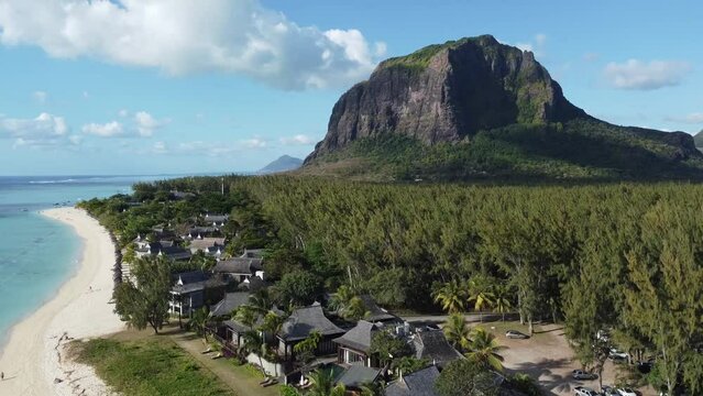 Le Morne tropical beach and famous kite, surf spot aerial panoramic view with palm trees and white sand blue ocean and sunbeds with umbrellas, Mauritius